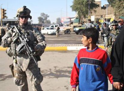 Un niño iraquí observa a un militar estadounidense en Bagdad.