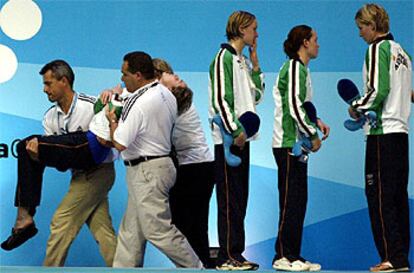 Momento en que los oficiales de la competición trasladan en brazos a Elka Graham desde el podio hacia la enfermería del Palau Sant Jordi.