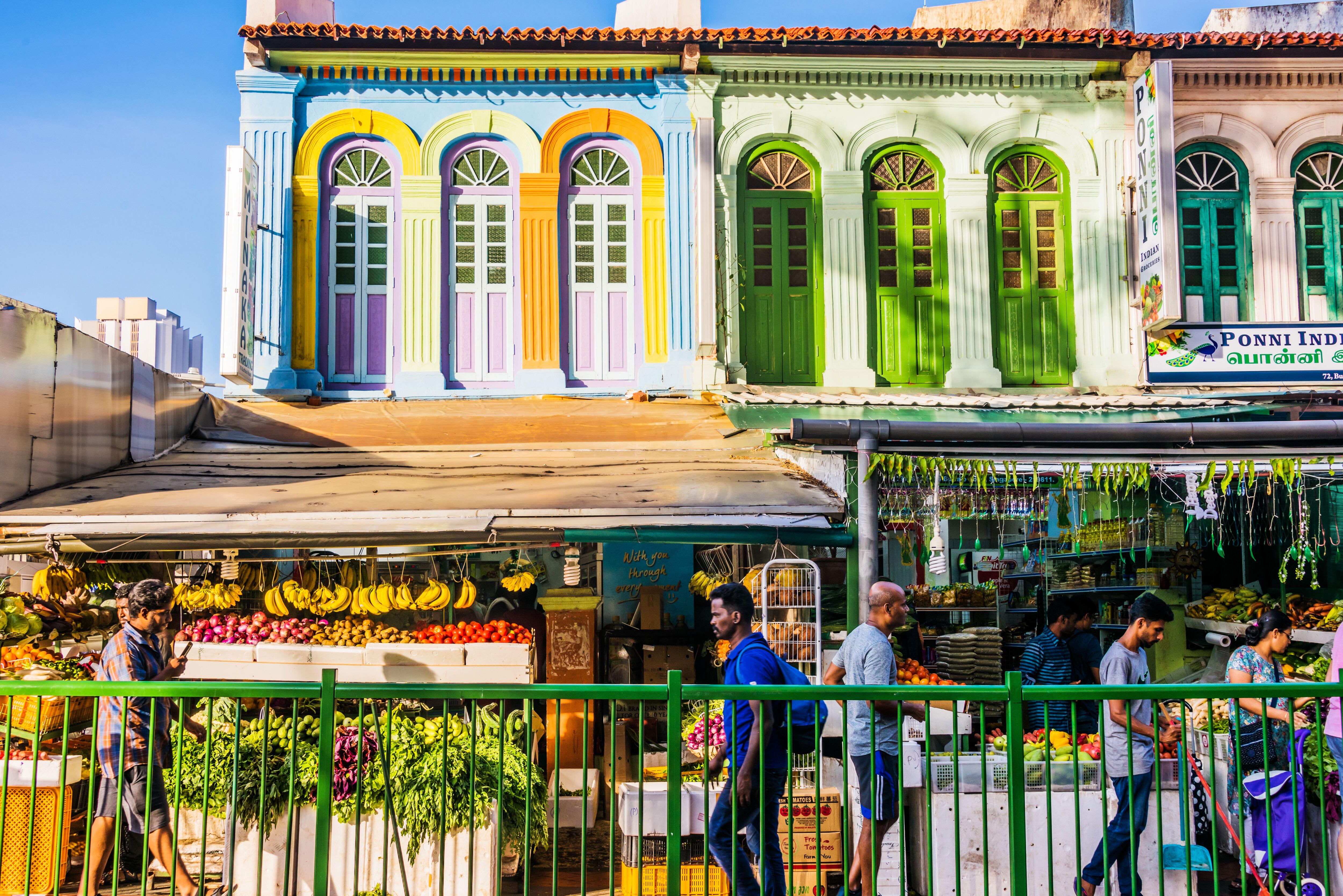 Un mercado callejero y, al fondo, unas casitas tradicionales estilo peranakan.