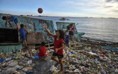 Niños juegan en una playa llena de plásticos en Manila (Filipinas).