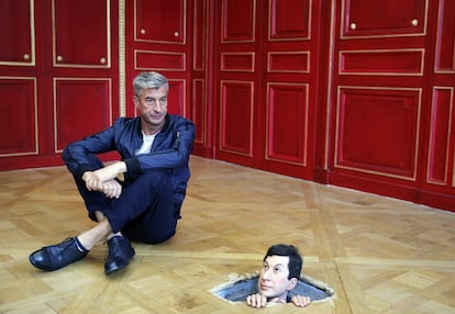 El artista italiano Maurizio Cattelan posa junto a su obra de arte "Sin título" (2001) en 2016 en París.