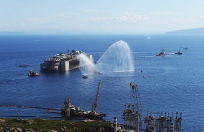 El crucero Costa Concordia que naufragó en la isla de Giglio en 2012 es remolcado al puerto de Génova donde será desmantelado.