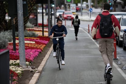 Varios ciclistas y un hombre en patinete circulan este lunes por el carril bici del paseo Teniente Flomesta, en la capital murciana.