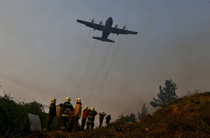 Un avión brasileño Hércules C-130 ayuda a combatir el incendio forestal que se aproxima a la comunidad de Dichato (Chile).