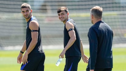 Los jugadores del FC Barcelona Ferran Torres (i) y Pedri (c) junto al técnico, Hansi Flick (d) durante el entrenamiento este lunes.