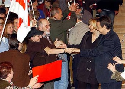 Zapatero y su esposa saludan a los asistentes al mitin de anoche en el Palacio de Congresos de Madrid.