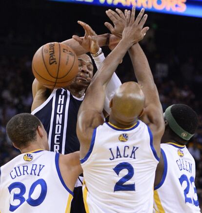 Westbrook, de los Thunder, es detenido por Curry, Jack y Green, de los Warriors.