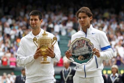 Djokovic and Nadal pose with their respective winner and runner-up's trophies at Wimbledon.