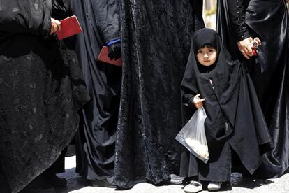 Una niña hace cola junto a su madre para poder votar en las urnas habilitadas en el lugar sagrado de Abdol Azim en la población de Shahre-Ray, al sur de Teherán.