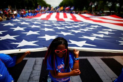 Una mujer sostiene una bandera estadounidense durante el desfile del 4 de julio, en Washington.