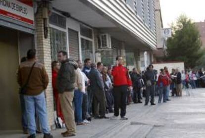 Decenas de personas esperan su turno ante una oficina del INEM en Madrid