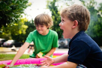 Dos niños juegan en el jardín.