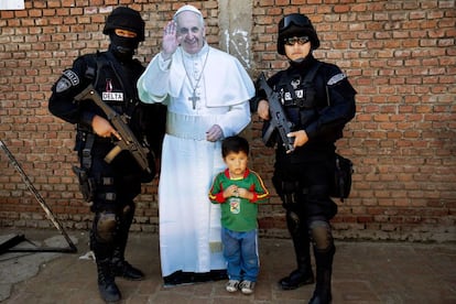 Jair Ortega y dos polic&iacute;as de las fuerzas especiales de Bolivia posan para una foto junto a una figura del papa Francisco despu&eacute;s de que el pont&iacute;fice abandonara la prisi&oacute;n de Palmasola en la localidad de Santa Cruz. La madre de Jair pidi&oacute; a los polic&iacute;as que posaran con su hijo porque le gustar&iacute;a ser agente del orden de mayor. 