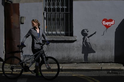 Una mujer sujeta su bicicleta por una calle en la ciudad de Dublín (Irlanda), el 7 de mayo de 2018.