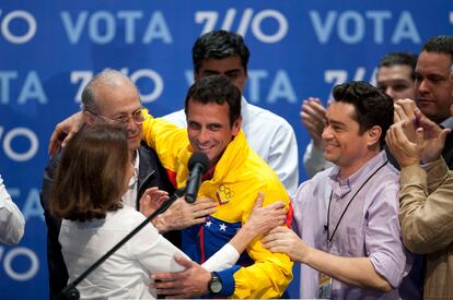 Capriles, junto a su madre Monica Radonski, es consolado por amigos y familiares tras asumir su derrota.