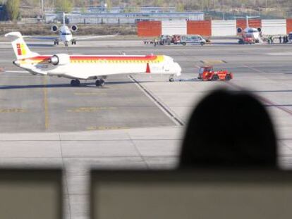 Dos personas observan uno de los aviones de Iberia en Barajas.
