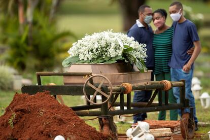 Un grupo de personas asiste al entierro de un familiar, víctima de covid-19 este 29 de abril, en el cementerio Campo da Esperança, en la ciudad de Brasilia.