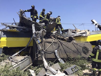 Miembros de los servicios de rescate permanecen en el lugar donde se produjo un choque frontal entre dos trenes en una línea de vía única entre Ruvo di Puglia y Corato, al sur de Italia.