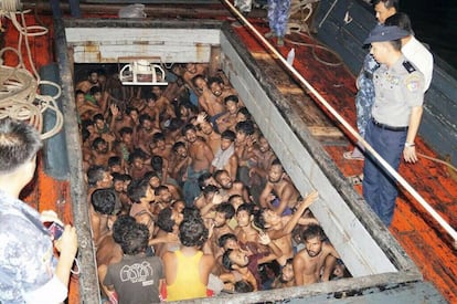 Fotografía proporcionada por el Ministerio de Información de Myanmar en la que se ve a un policía hablando con un grupo de imigrantes hacinados en un barco pesquero frente a la costa occidental de Rakhine.