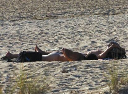 Dos bañistas practican el nudismo en la playa de Cortadura, Cádiz.