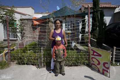 Dulce Alonso y uno de sus hijos, frente a su propiedad.