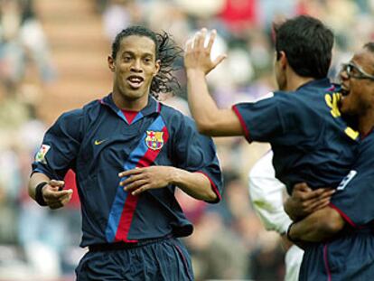 Ronaldinho corre a felicitar a Saviola, abrazado por Davids, tras el gol del argentino.