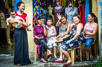 Un grupo de mujeres frente a un comercio de ropa femenina.