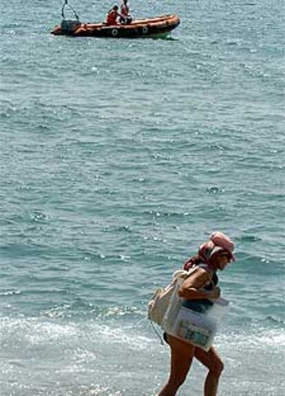 Una <i>zodiac</i> de la Cruz Roja recorre la zona de la playa de la Barceloneta donde se ha encontrado el cadáver.