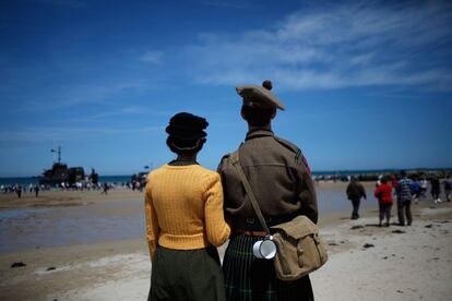 Una pareja vestida de &eacute;poca mira hacia el mar en la playa de Arromanches, al oeste de Francia, en le d&iacute;a del 70 aniversario del desembarco de Normand&iacute;a. 