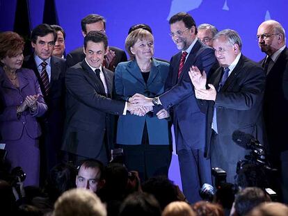 La canciller alemana, Angela Merkel, el presidente francés, Nicolás Sarkozy, y Mariano Rajoy unen sus manos al final del mitin.