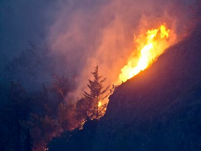 Flames are visible from the Beluga Point parking area near Anchorage, Alaska, on July 19, 2016, as a wildfire near McHugh Creek burns.