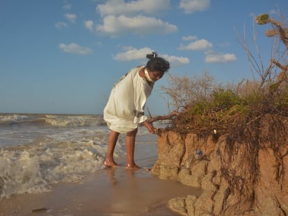 Una mujer de la comunidad wayuu Twuliá, en La Guajira (Colombia), toca un tramo de tierra erosionado.