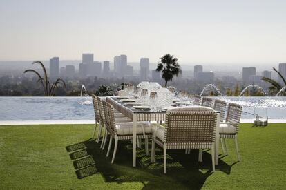 Do lado de fora, um espaço para refeições ao ar livre ao lado da piscina infinita de 25 metros, com vista para a cidade de Los Angeles.