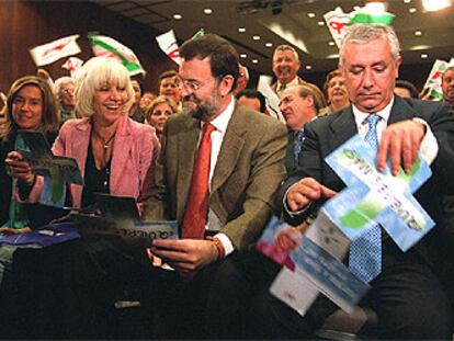 Teófila Martínez, Mariano Rajoy y Javier Arenas despliegan un folleto electoral.