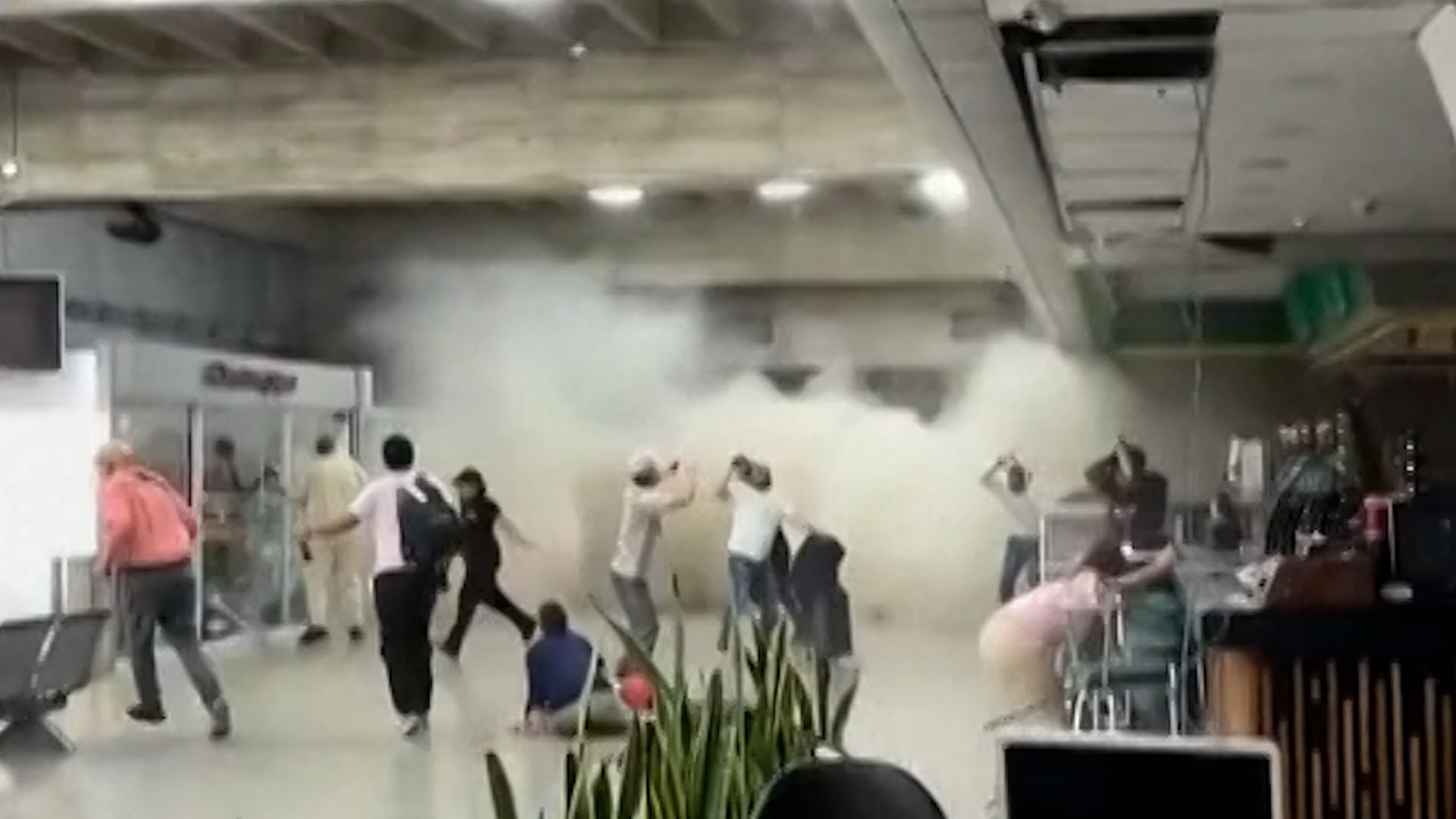 Un viajero recoge con su teléfono móvil el desplome de un techo en la terminal del aeropuerto Simón Bolívar de Maiquetia por el efecto de los terremotos en Venezuela.