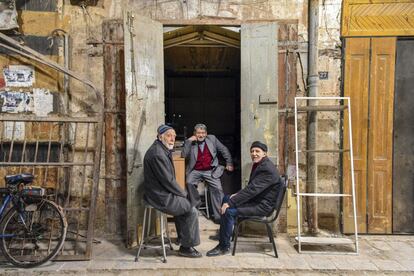 Aleppo, 2019. Três homens posam para um retrato junto a suas lojas no bazar Al-Mahmas. <p><i>“Apesar de toda a destruição, do estresse e da falta de recursos em plena guerra, os moradores de Aleppo sempre demonstraram profundo amor por sua cidade. Inclusive nos momentos mais sombrios, compartilharam e procuraram soluções para sobreviver. Ver os sorrisos desses comerciantes faz a gente sentir que nada é capaz de parar a roda da vida.” </i></p>