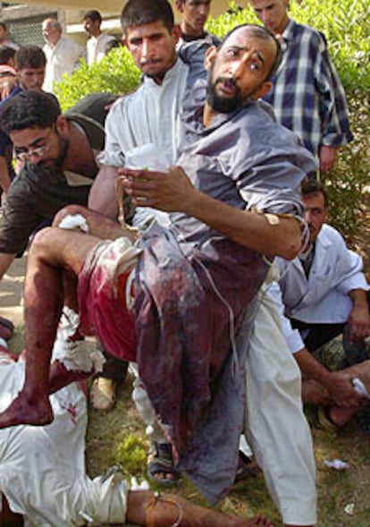 Un iraquí traslada a un herido en Kufa