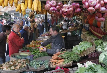 Un productor de hortalizas atiende a varios clientes en la feria de Gernika.