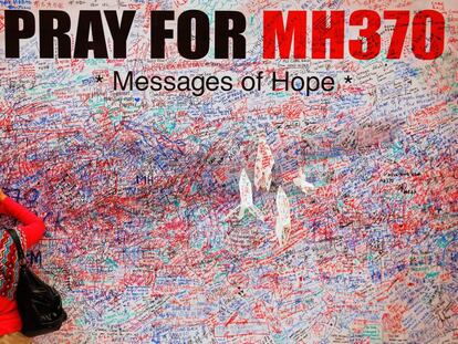 Una mujer escribe un mensaje en un mural en recuerdo de las víctimas del vuelo MH370, en el centro de Kuala Lumpur en marzo de 2014. 