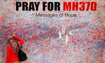 Una mujer escribe un mensaje en un mural en recuerdo de las víctimas del vuelo MH370, en el centro de Kuala Lumpur en marzo de 2014.