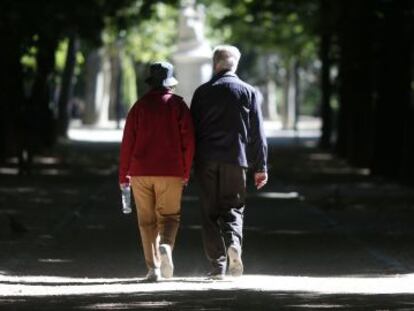 Una pareja mayor camina en el madrileño parque de El Retiro.
