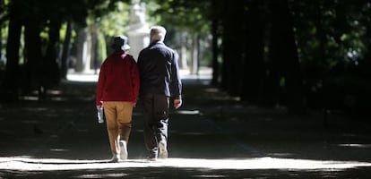 Una pareja mayor camina en el madrileño parque de El Retiro.