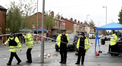 Agentes de policía, en la calle en la que ha tenido lugar esta madrugada un tiroteo en Mánchester durante una fiesta de Carnaval.