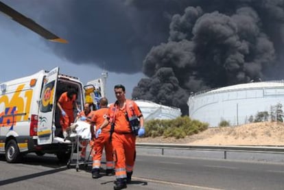 Uno de los heridos es evacuado del incendio de la refinería de Cepsa en Palos (Huelva).
