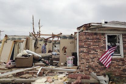 Uns vizinhos de Little Rock (Arkansas) olham o estado em que ficou sua casa depois do tornado.