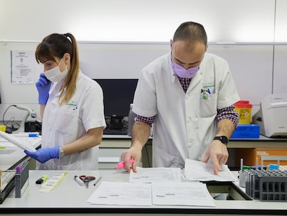 Dos sanitarios del laboratorio del Hospital Clínic de Barcelona gestionan los resultados de las analíticas de forma manual tras el ciberataque al centro sanitario.