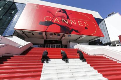 Varios trabajadores instalan la alfombra roja ante el Palacio del Festival en la jornada inaugural del 70º Festival de Cine de Cannes. El certamen se celebra del 17 al 28 de mayo.