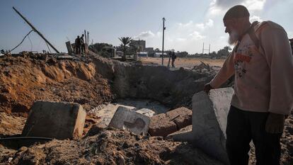 Un hombre ante el cráter dejado por un bombardeo aéreo israelí en la localidad de Deir al-Balah, este miércoles en Gaza.