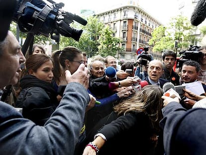 Los periodistas <i>acorralan</i> a Fraga a su llegada a la sede del PP. A la izquierda, con la mano alzada, el hombre que le pidió que dimitiera.