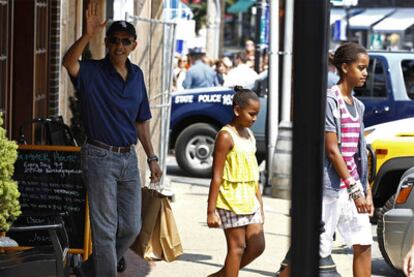 Barack Obama y sus hijas, Sasha y Malia, salen de un restaurante en su primer día de vacaciones.